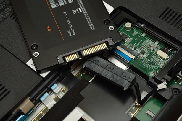Kỹ thuật viên đang nâng cấp SSD cho laptop, cải thiện tốc độ nhanh hơn
